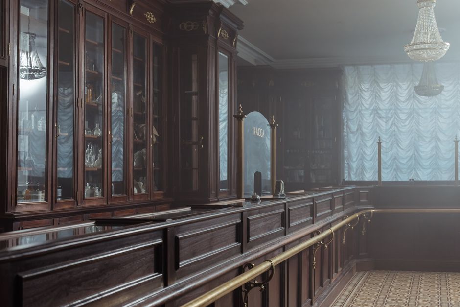 Historical pharmacy interior featuring vintage wooden cabinets and counters.